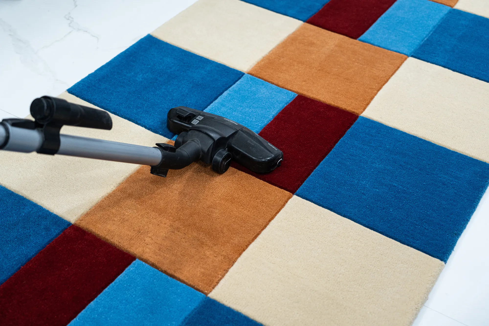 Vacuuming a handcrafted wool rug for everyday care.